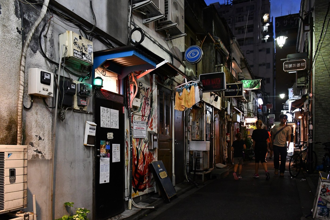 A narrow lantern-lit alley of tiny two-storey bars in Golden Gai, Shinjuku, at night