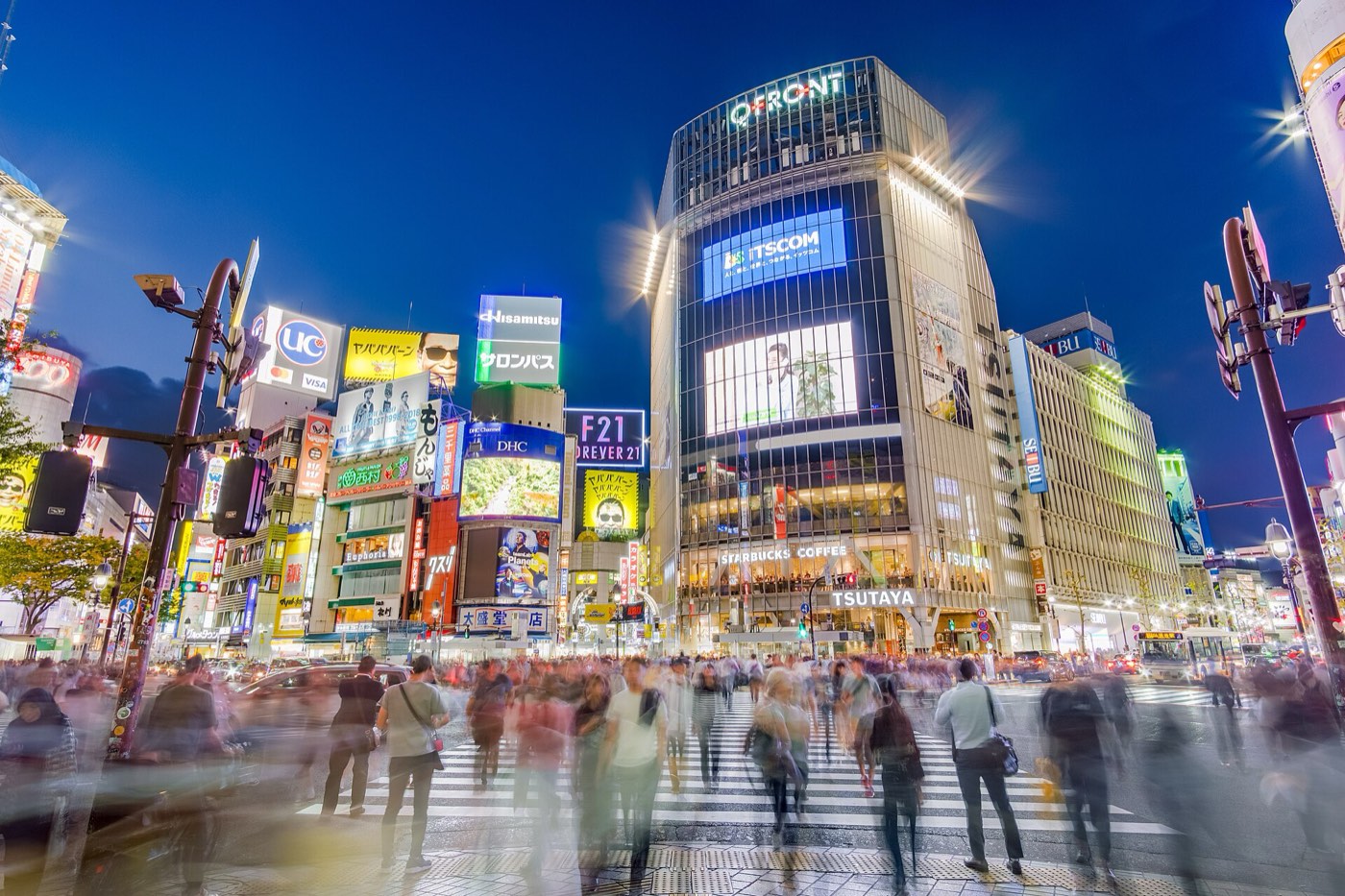 Shibuya scramble crossing seen from above, pedestrians crossing in every direction